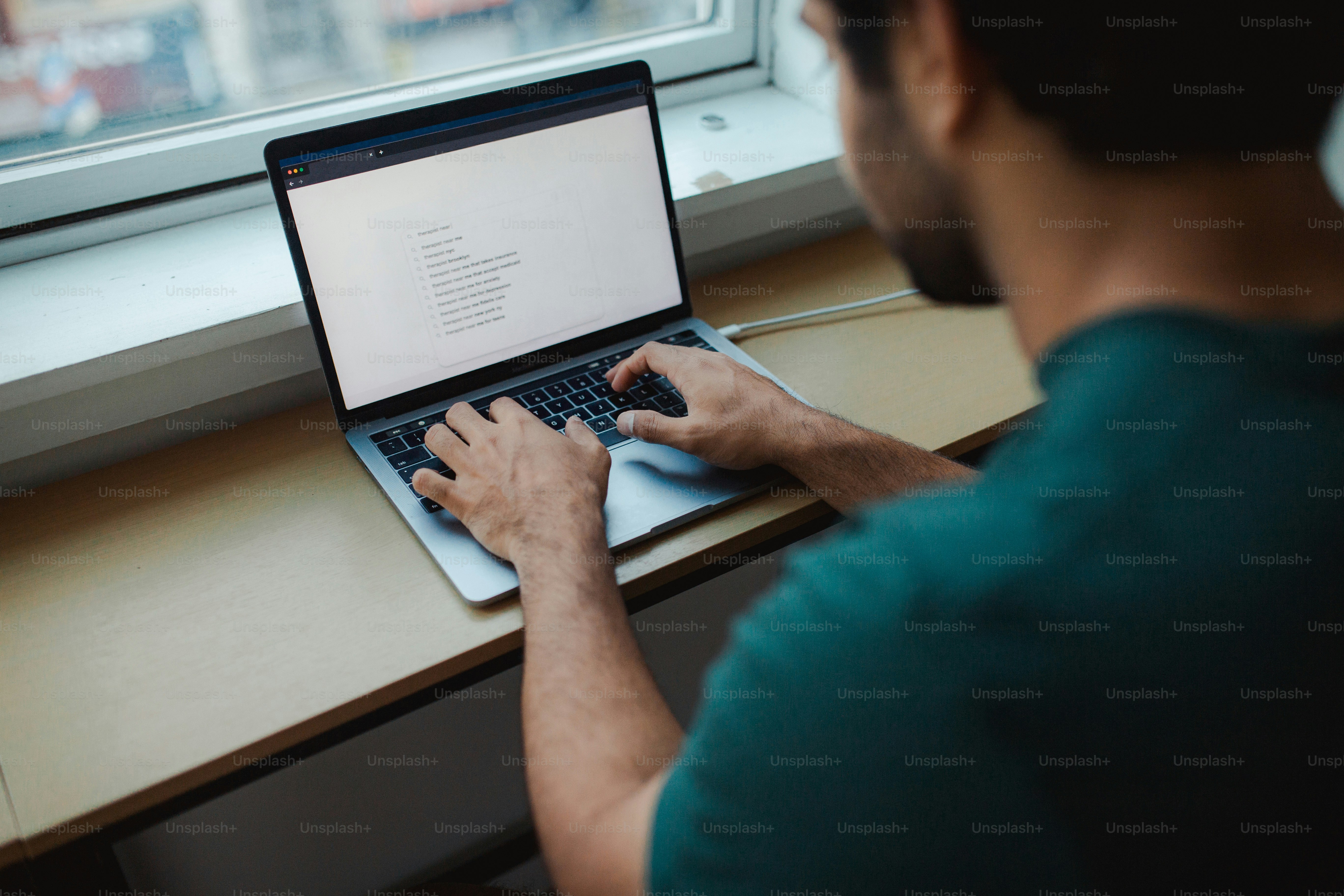 a man sitting at a table using a laptop computer